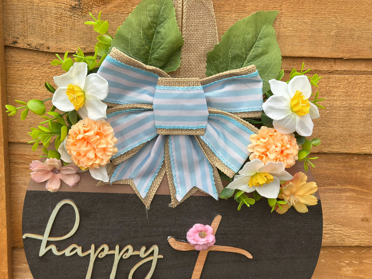Rustic farmhouse-style Easter wreath, handcrafted with love, featuring artificial flowers and a wooden base.