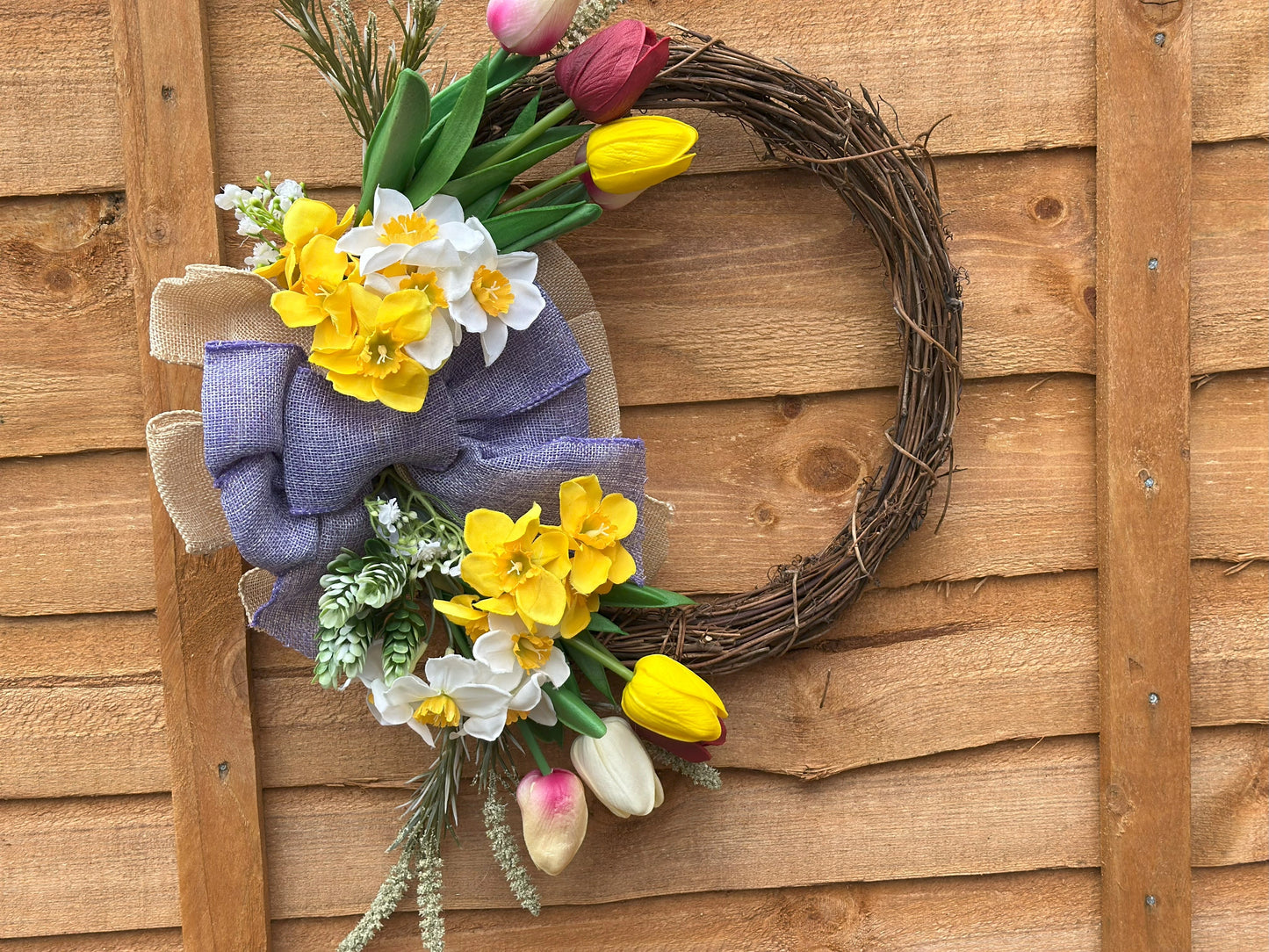 Easter-inspired artificial flower wreath with tulips and daffodils, adding warmth and coziness to your space.