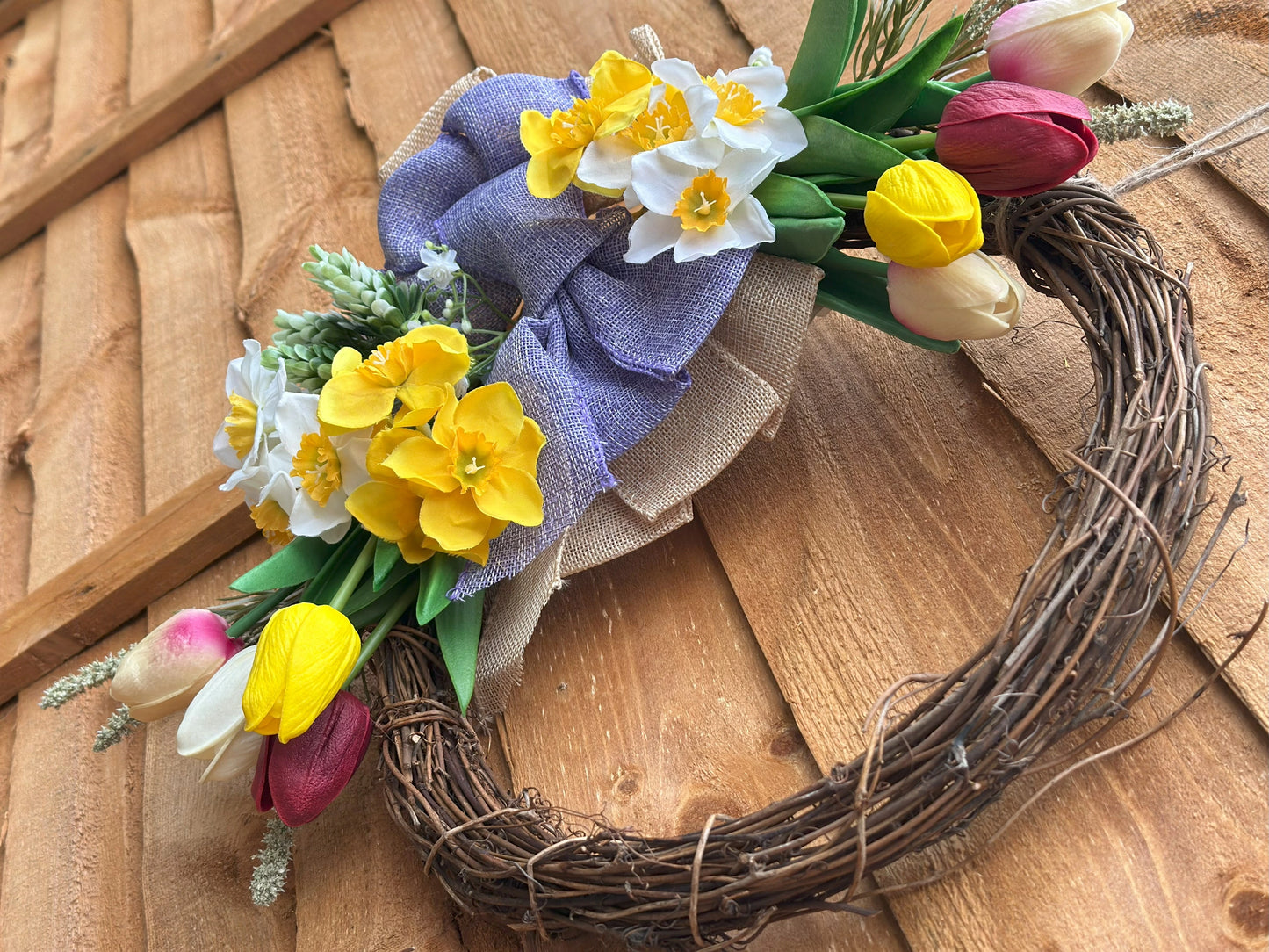 Easter-inspired artificial flower wreath with tulips and daffodils, adding warmth and coziness to your space.