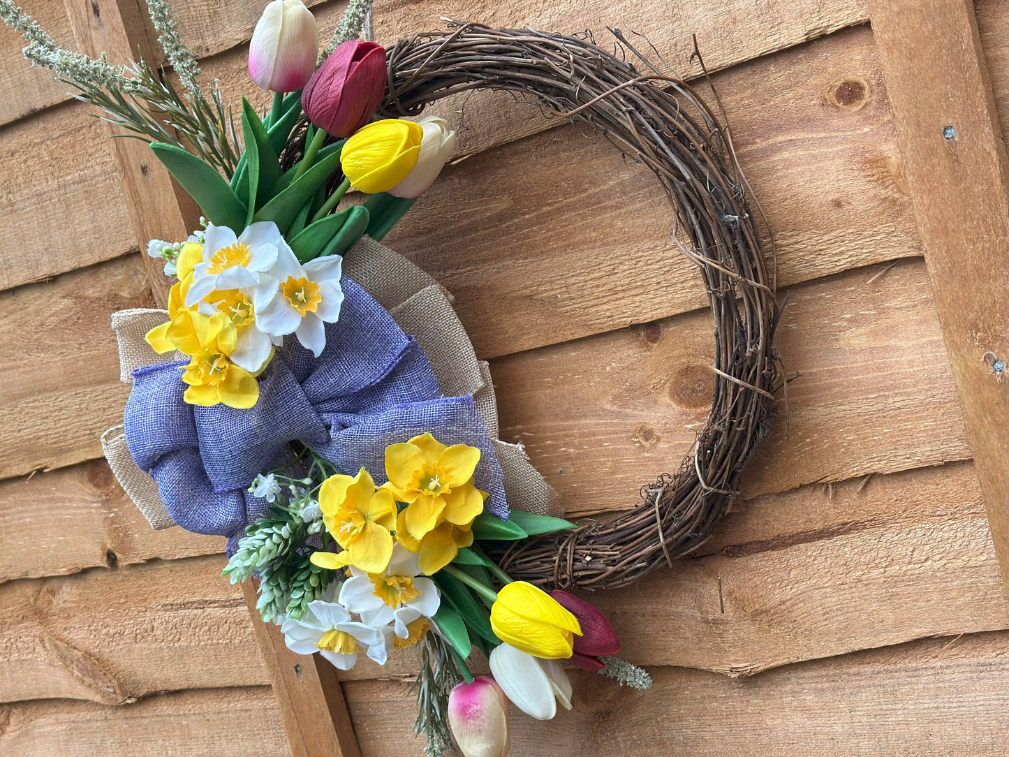 Easter-inspired artificial flower wreath with tulips and daffodils, adding warmth and coziness to your space.