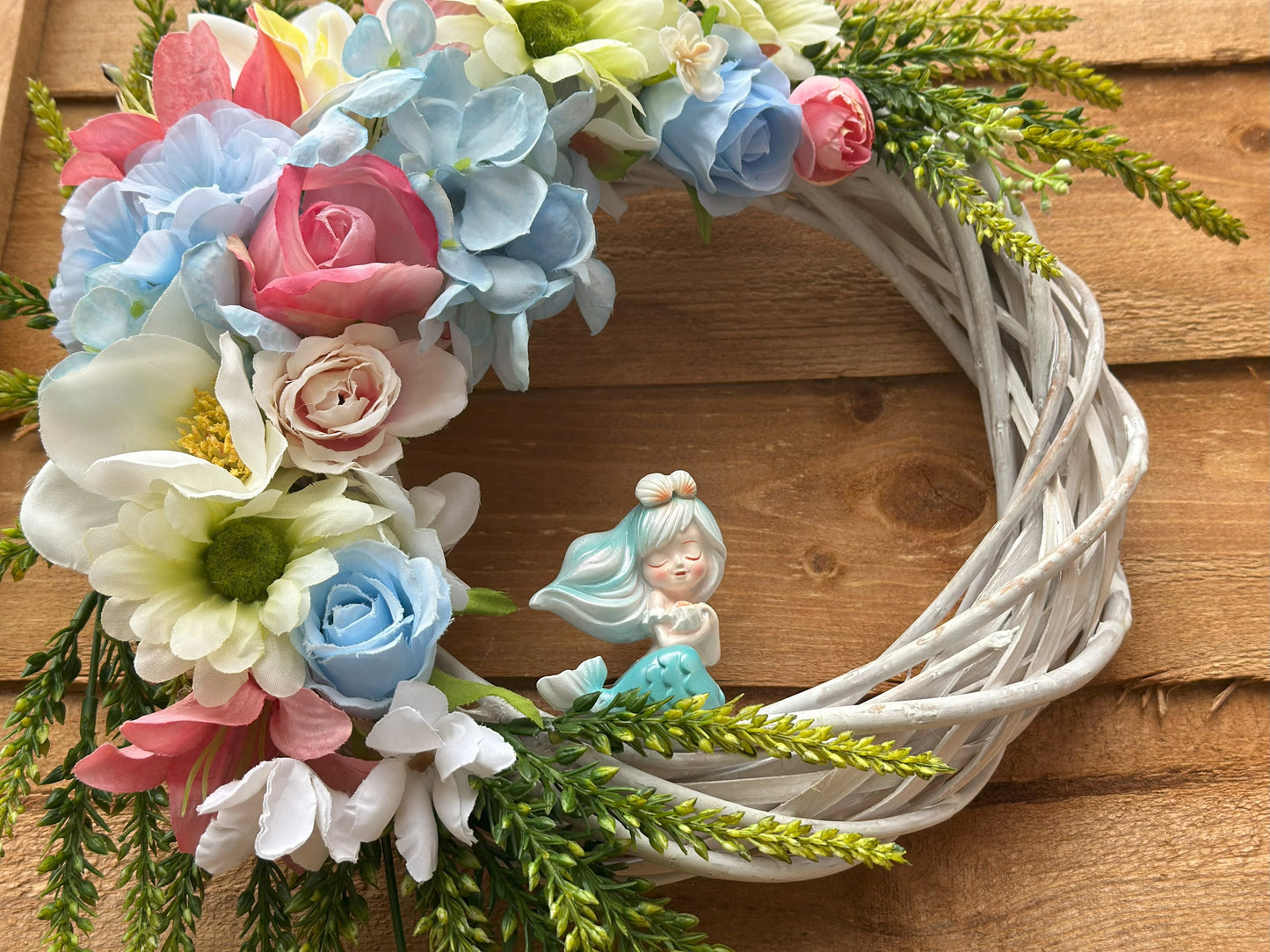 Sea Breeze Mermaid Wreath – a unique handmade coastal decor piece with a mermaid figurine and summer-inspired artificial blooms.