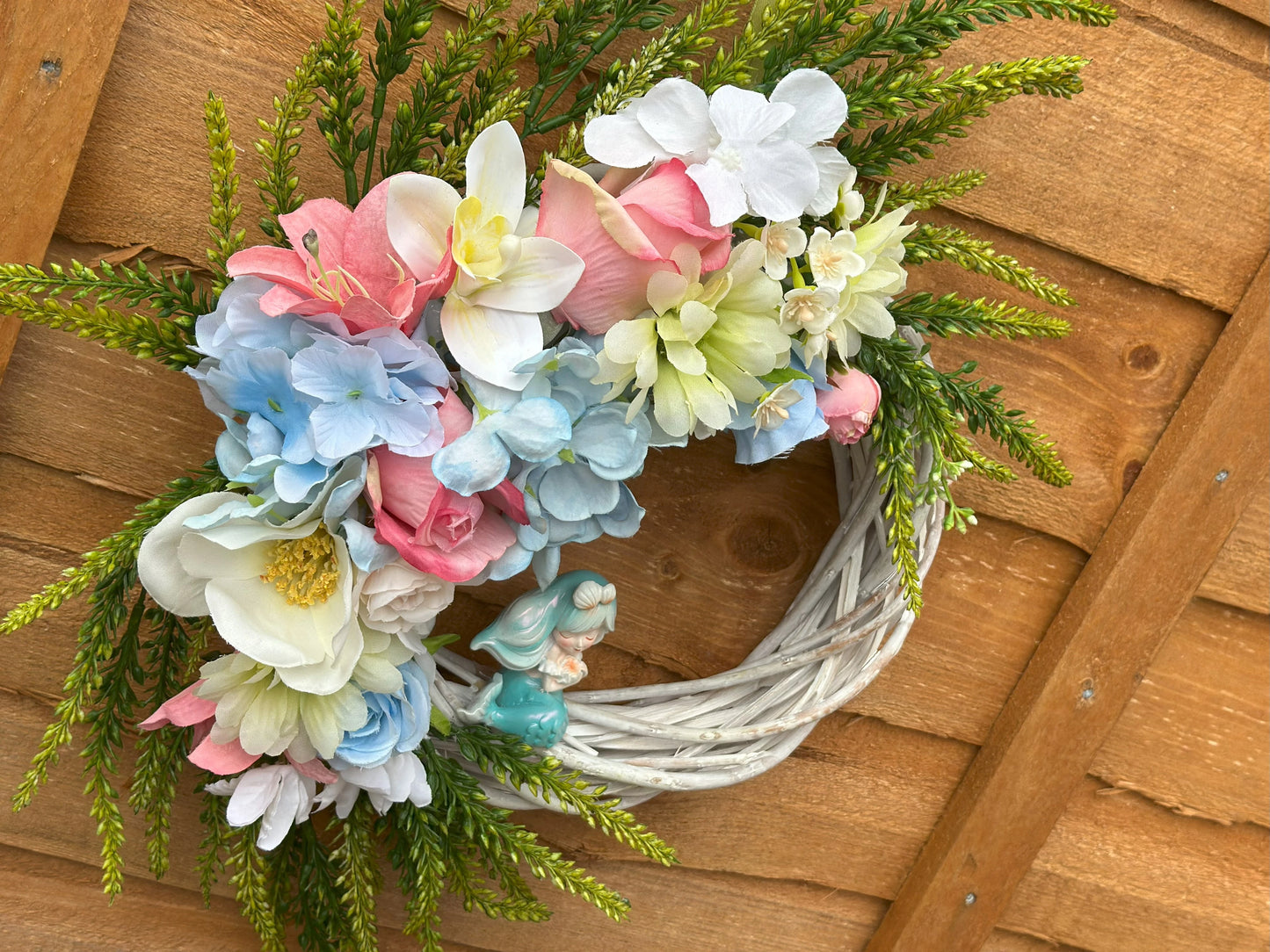 Sea Breeze Mermaid Wreath – a unique handmade coastal decor piece with a mermaid figurine and summer-inspired artificial blooms.
