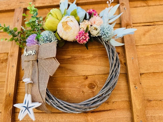 Detail of floral wreath with "home" sign in nautical style.