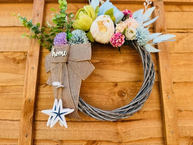 Detail of floral wreath with "home" sign in nautical style.