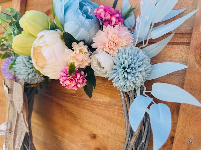 Round wreath with soft-colored flowers, suitable for indoor and outdoor decor.