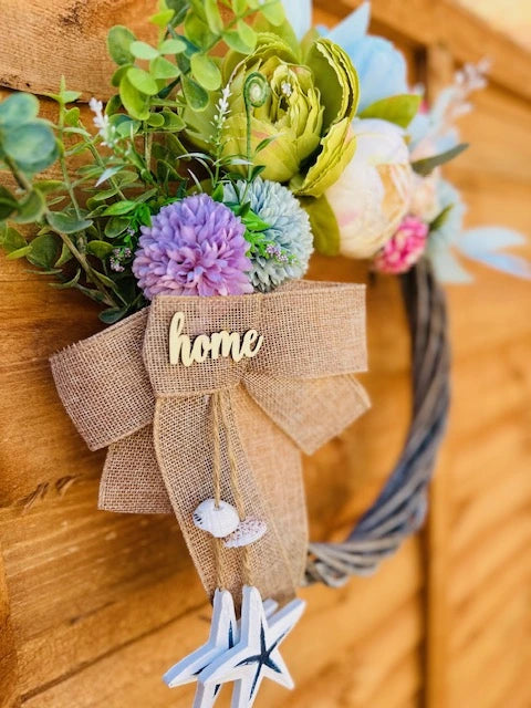 Round wreath with soft-colored flowers, suitable for indoor and outdoor decor.