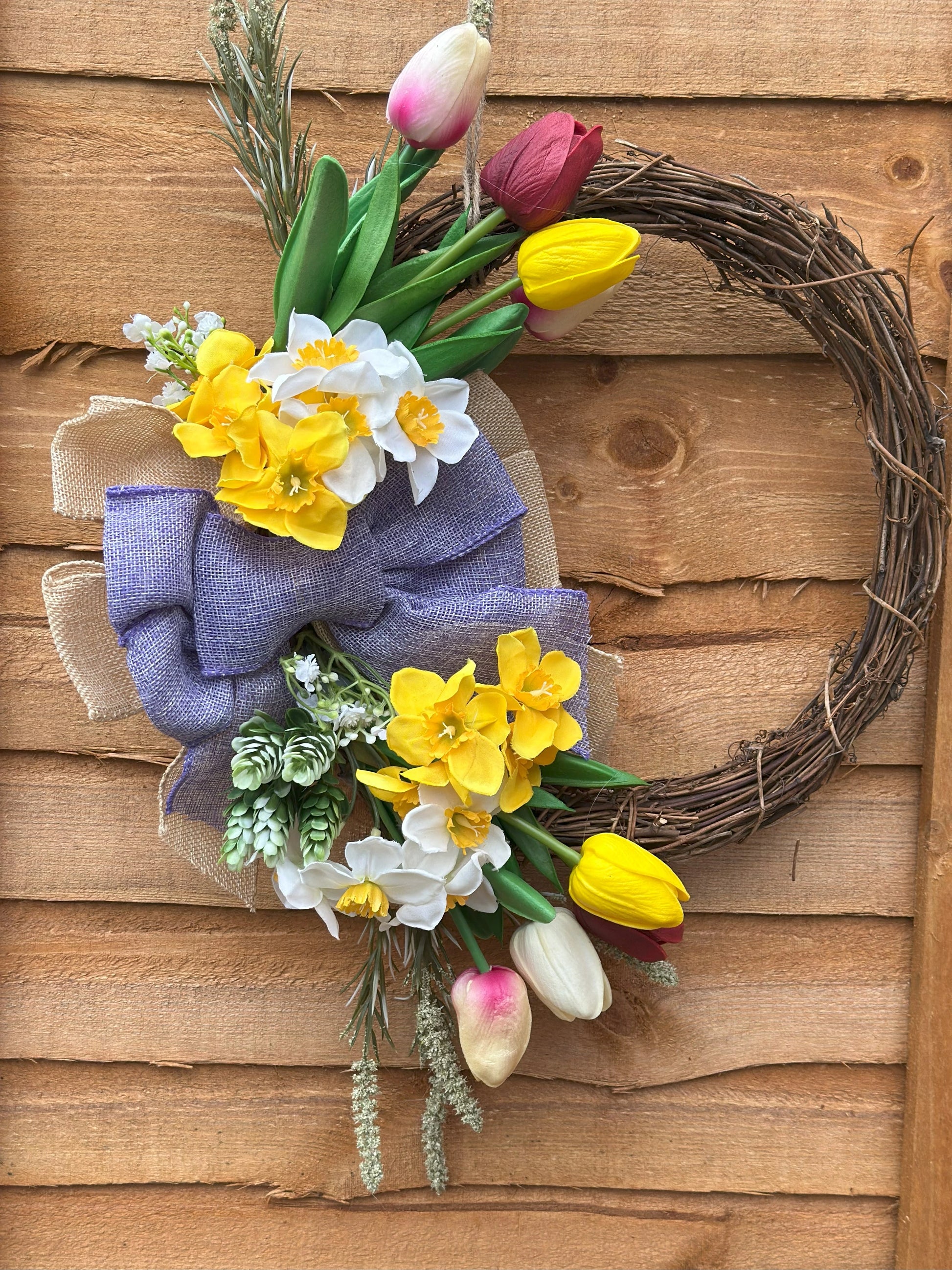 Easter-inspired artificial flower wreath with tulips and daffodils, adding warmth and coziness to your space.
