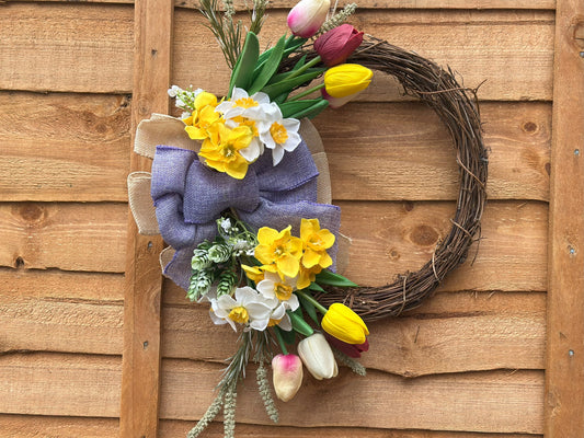 handmade wreath with seasonal artificial flowers and fairy ornament.