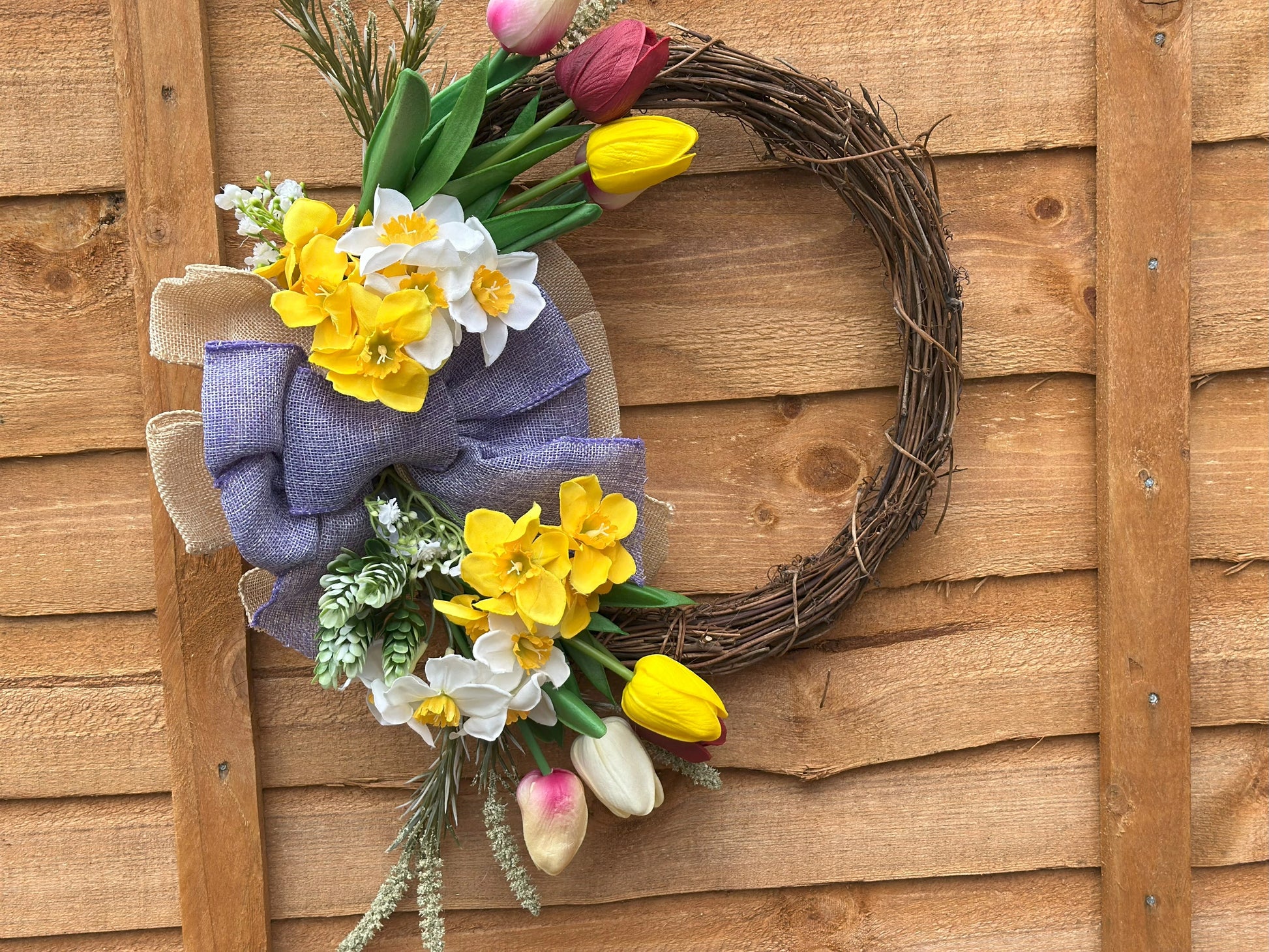 Easter-inspired artificial flower wreath with tulips and daffodils, adding warmth and coziness to your space.