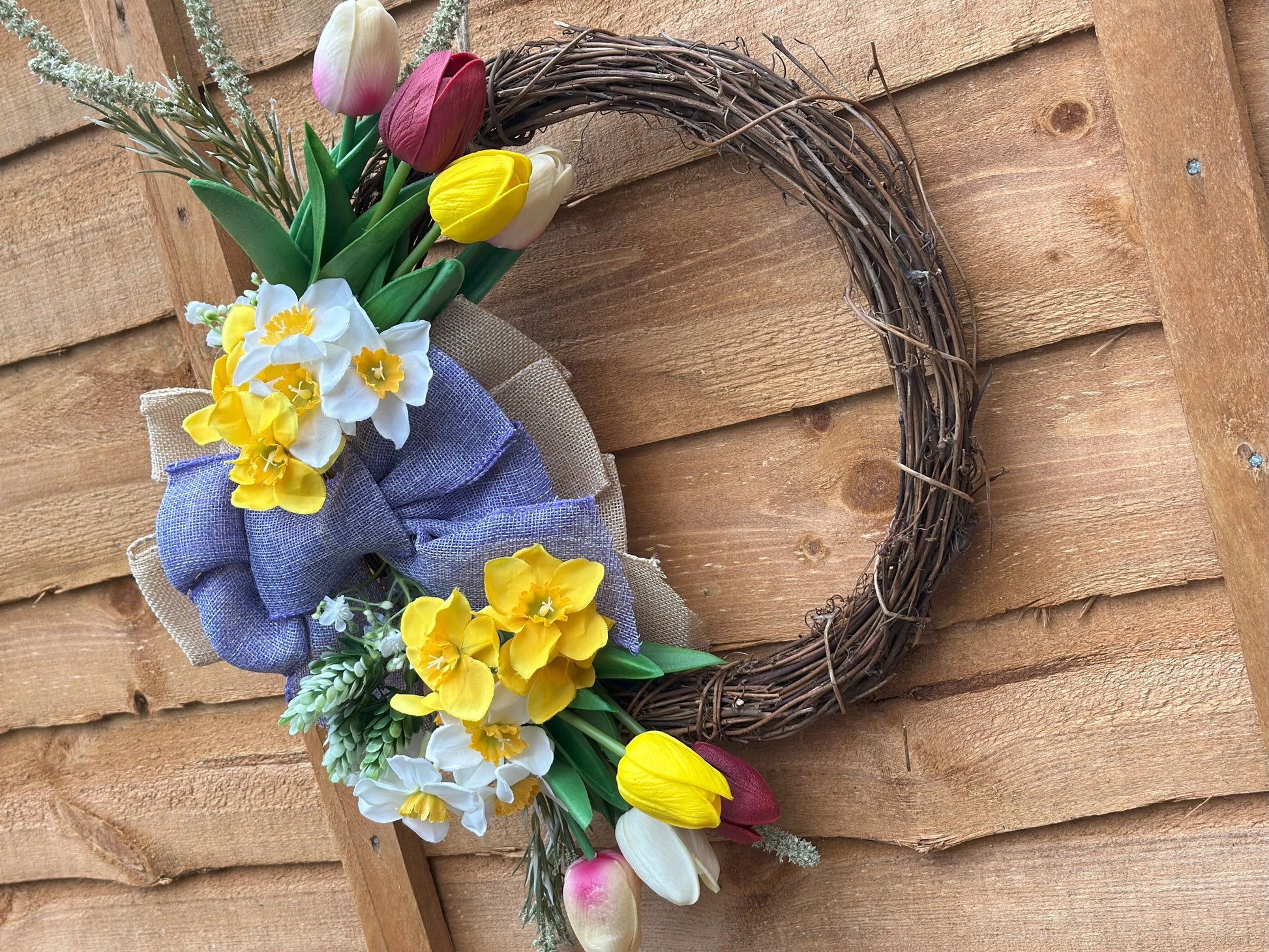 Easter-inspired artificial flower wreath with tulips and daffodils, adding warmth and coziness to your space.
