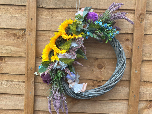 Handmade floral wreath with artificial sunflowers, lavender, and a fairy figurine – perfect for home decor and front door decoration.