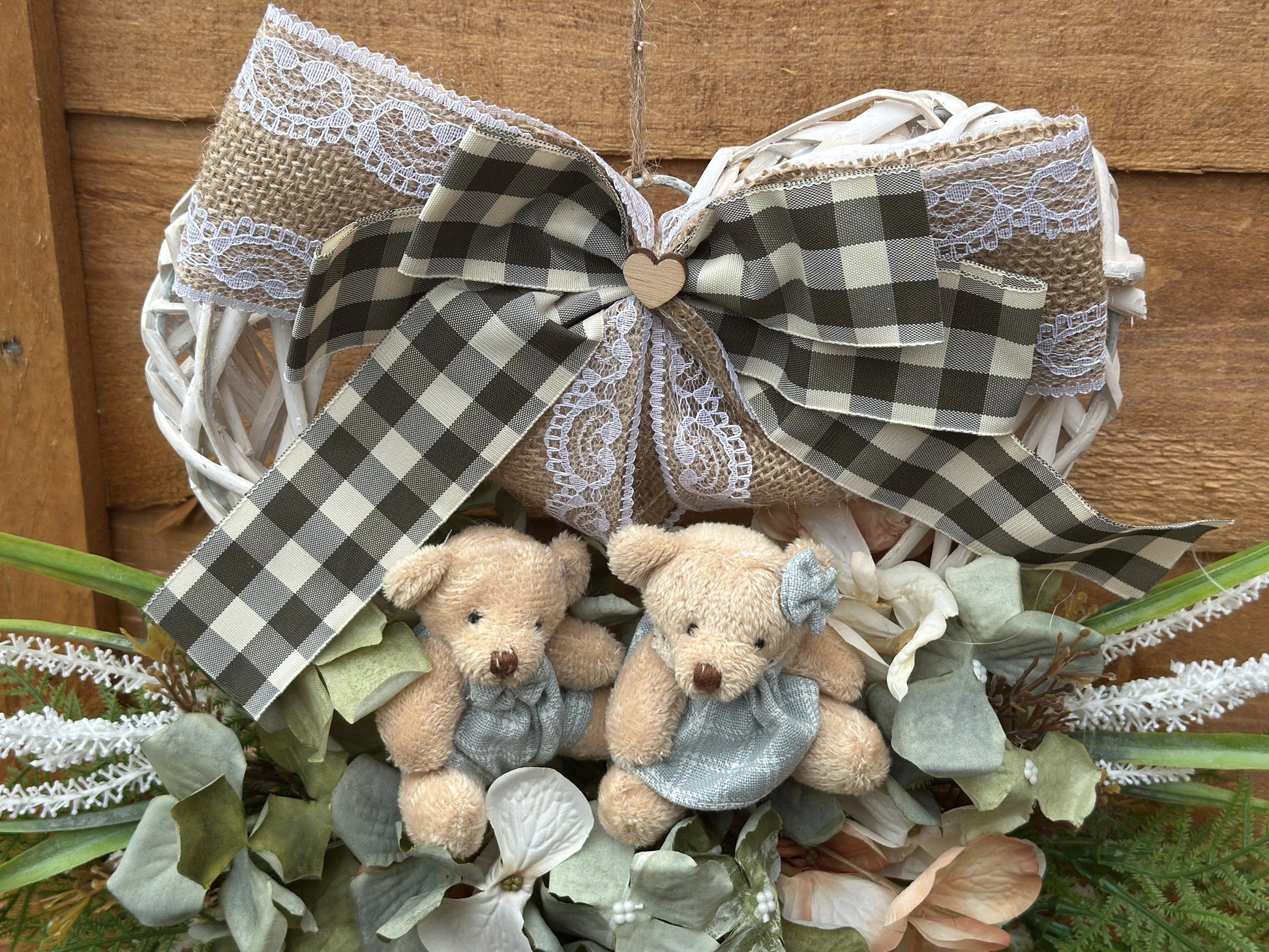 "Handmade heart-shaped wreath with teddy bears, artificial flowers, and a rustic burlap bow. Vintage-style home decor, perfect for housewarming gifts, nursery decoration, and front door wreaths. Romantic and family-inspired wooden wreath for indoor and outdoor use."