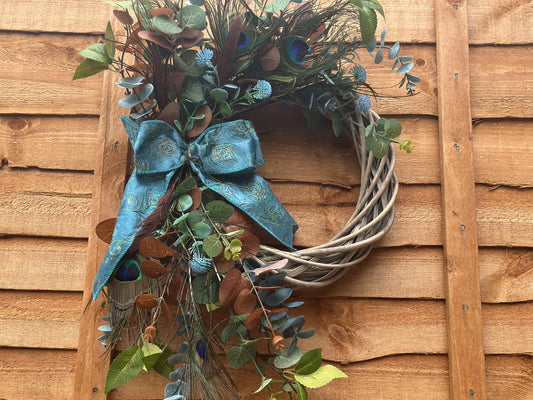 Handmade luxury peacock wreath with artificial flowers, peacock feathers, and Victorian-style lace ribbon. Elegant vintage wall and door décor for year-round aristocratic home styling