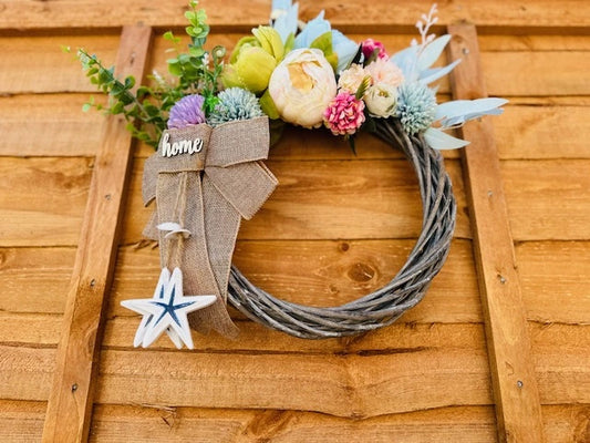 Handmade wreath with pastel artificial flowers and ceramic starfish.