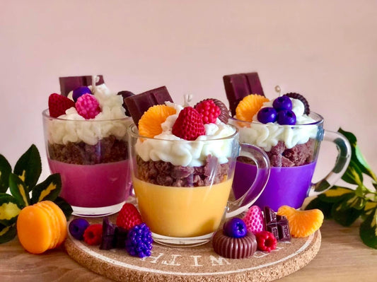 Handmade dessert-inspired scented candles in glass cups, featuring whipped wax, chocolate, and fruit decorations. Luxury soy wax candles for home décor, unique gifts, and long-lasting fragrance.